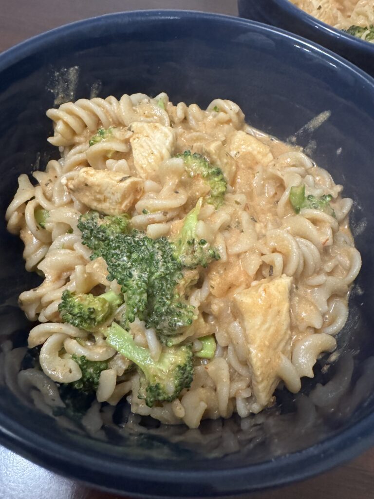 This image is a close up of the gluten free rotini pasta. you can see the creamy chicken sauce with broccoli over the noodles.