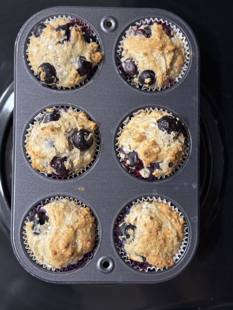 This image is a small muffin tin with 6 gluten free muffins fully bakes inside each spot.